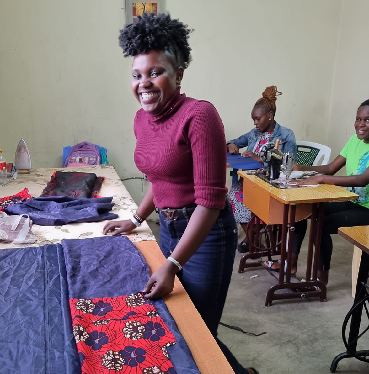 An OnCourse tailoring student working with fabric in the classroom