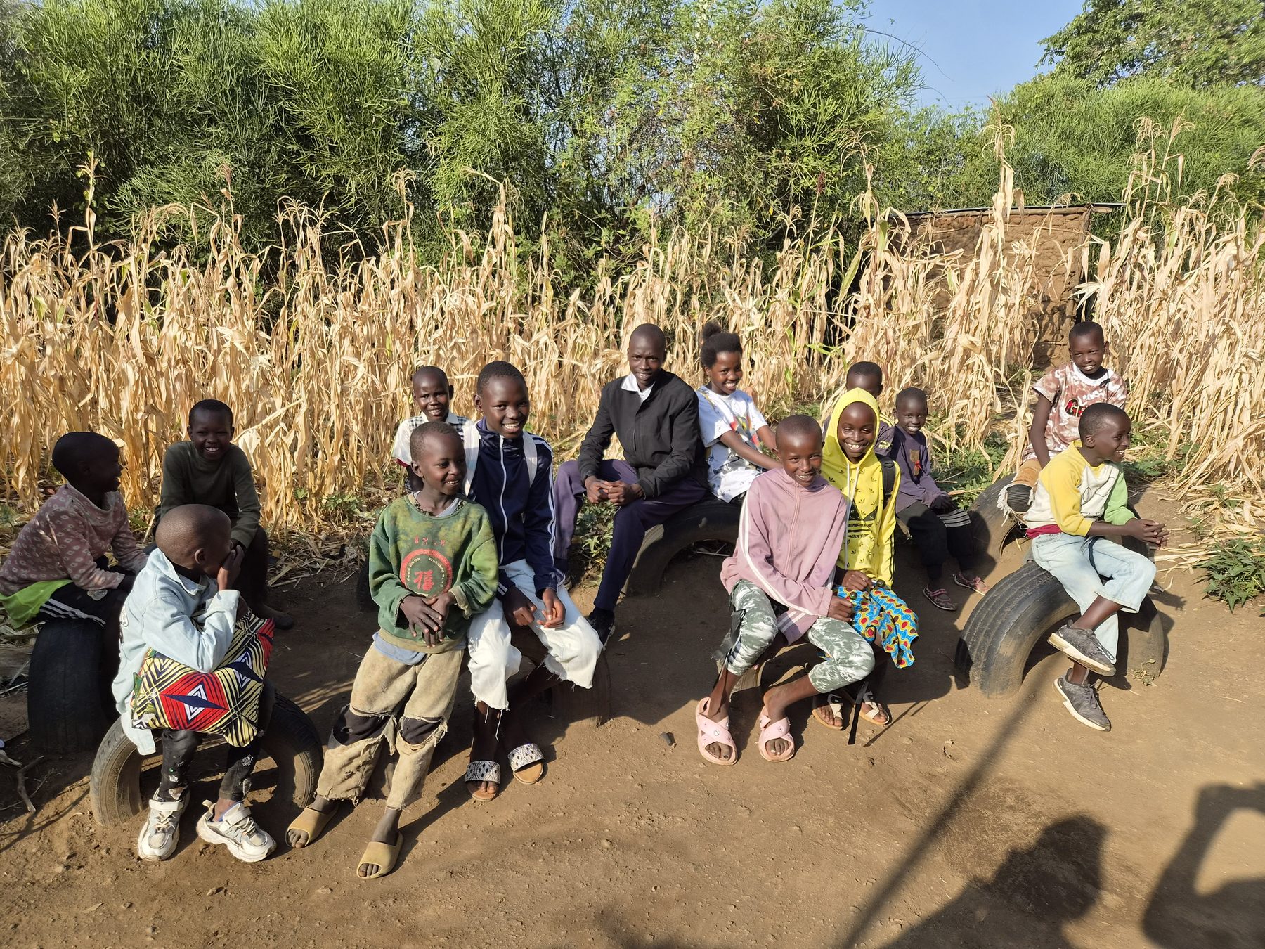 A group of children sitting together beside a maize field in Kenya
